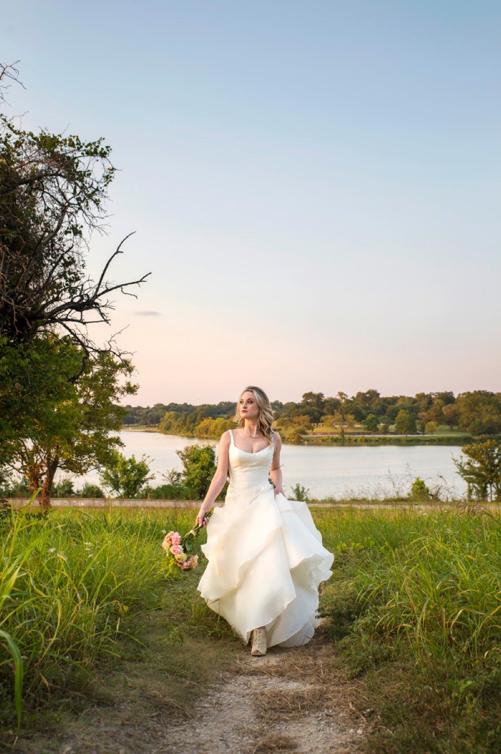 A bride at golden hour on the shore of White Rock Lake in Dallas
