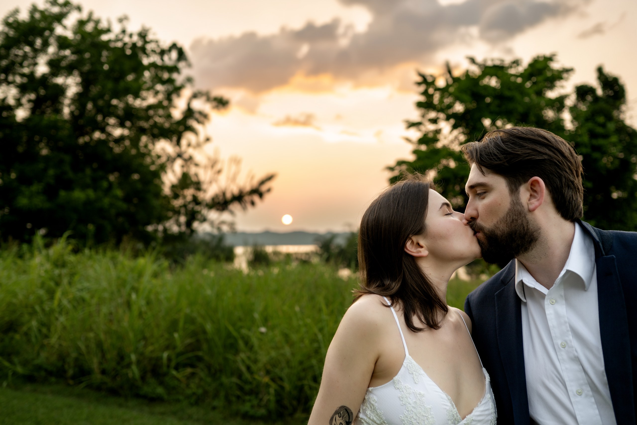 An engaged couple kissing at sunset over White Rock Lake, Dallas